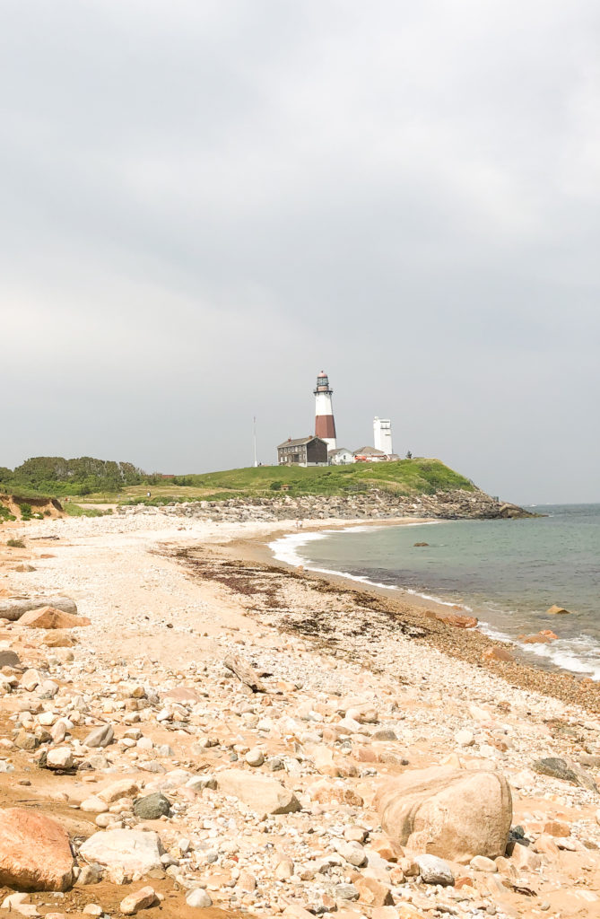 A rocky beach leading to a lighthouse in Montauk, a popular road trip destination