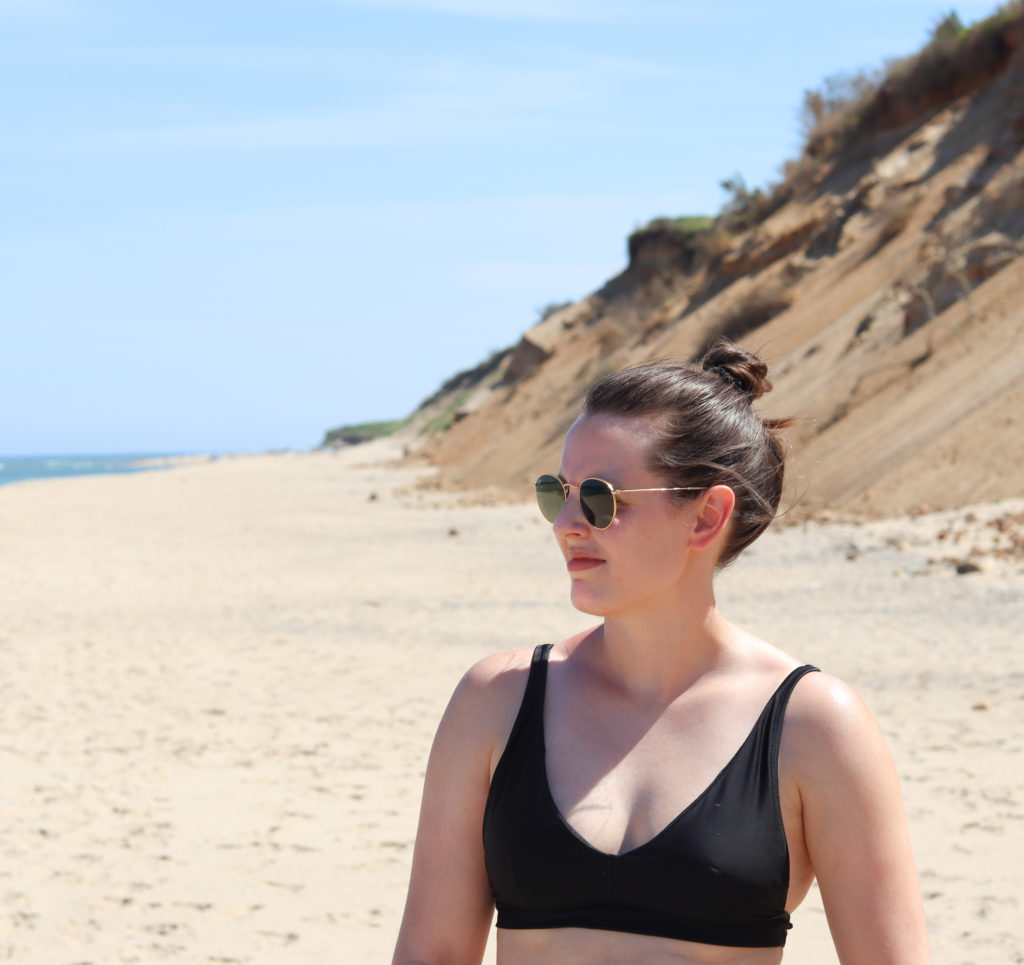 A women standing on a beach in Cape cod, a popular summer road trip