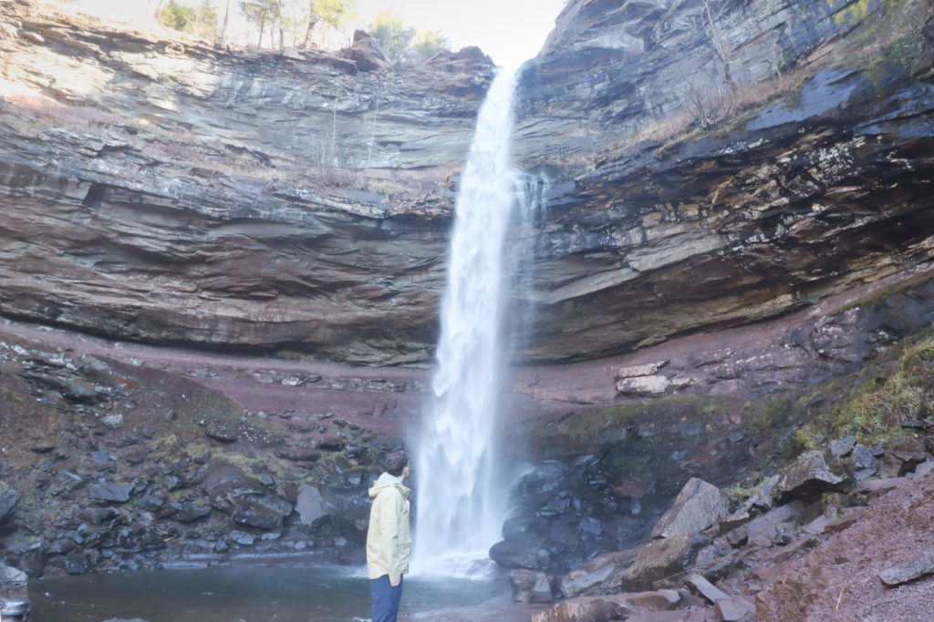 Man standing in front of Kaaterskill Falls waterfall