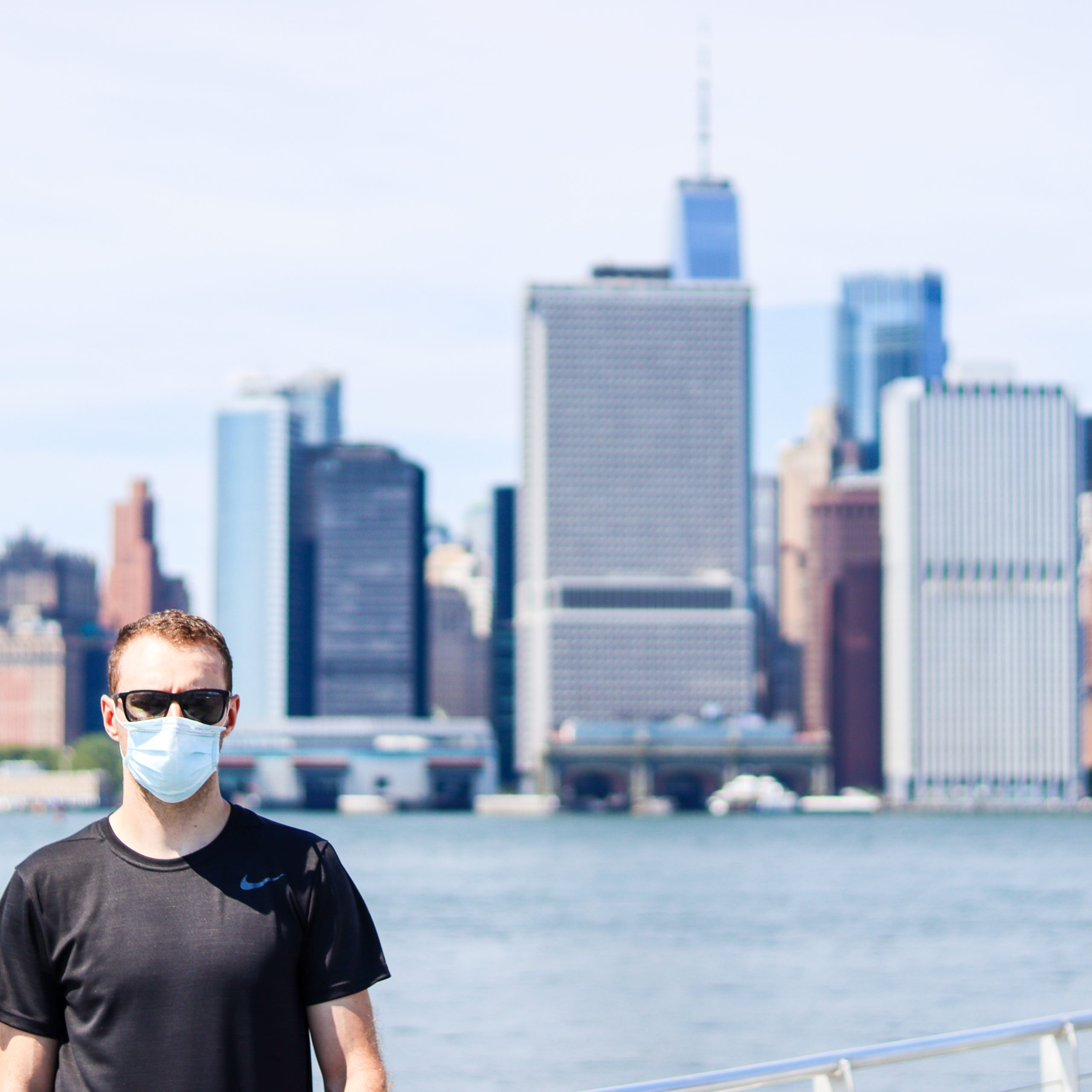 Man standing in front of Manhattan skyline view from Governors Island 