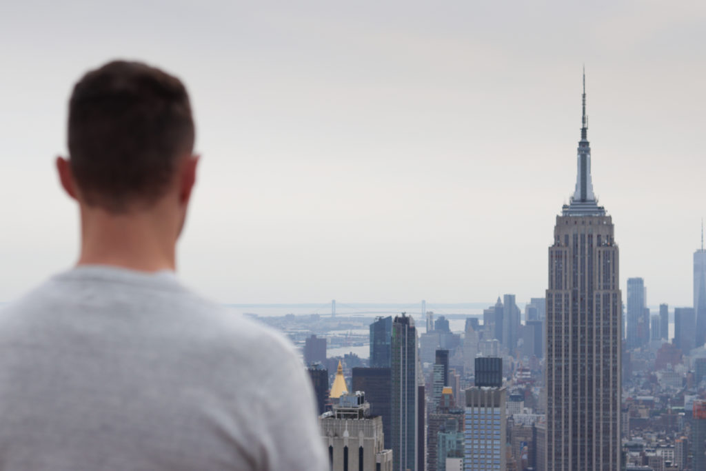 Man facing outwards, looking at the Manhattan skyline.