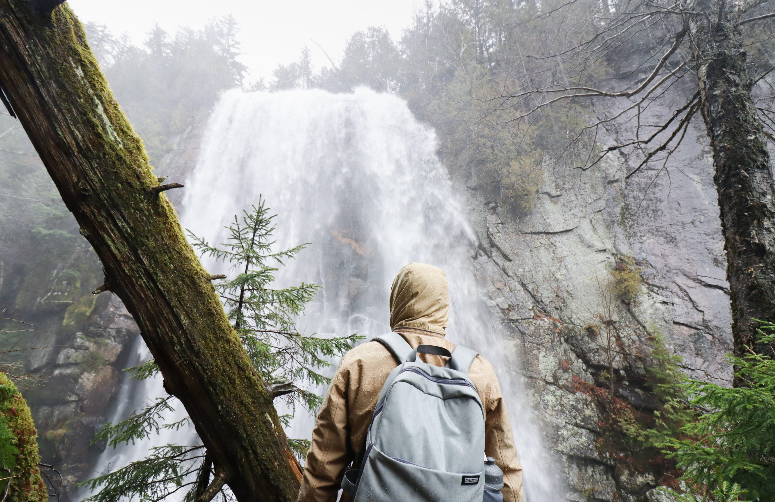 Man standing in front of Rainbow Falls while Hiking Indian Head