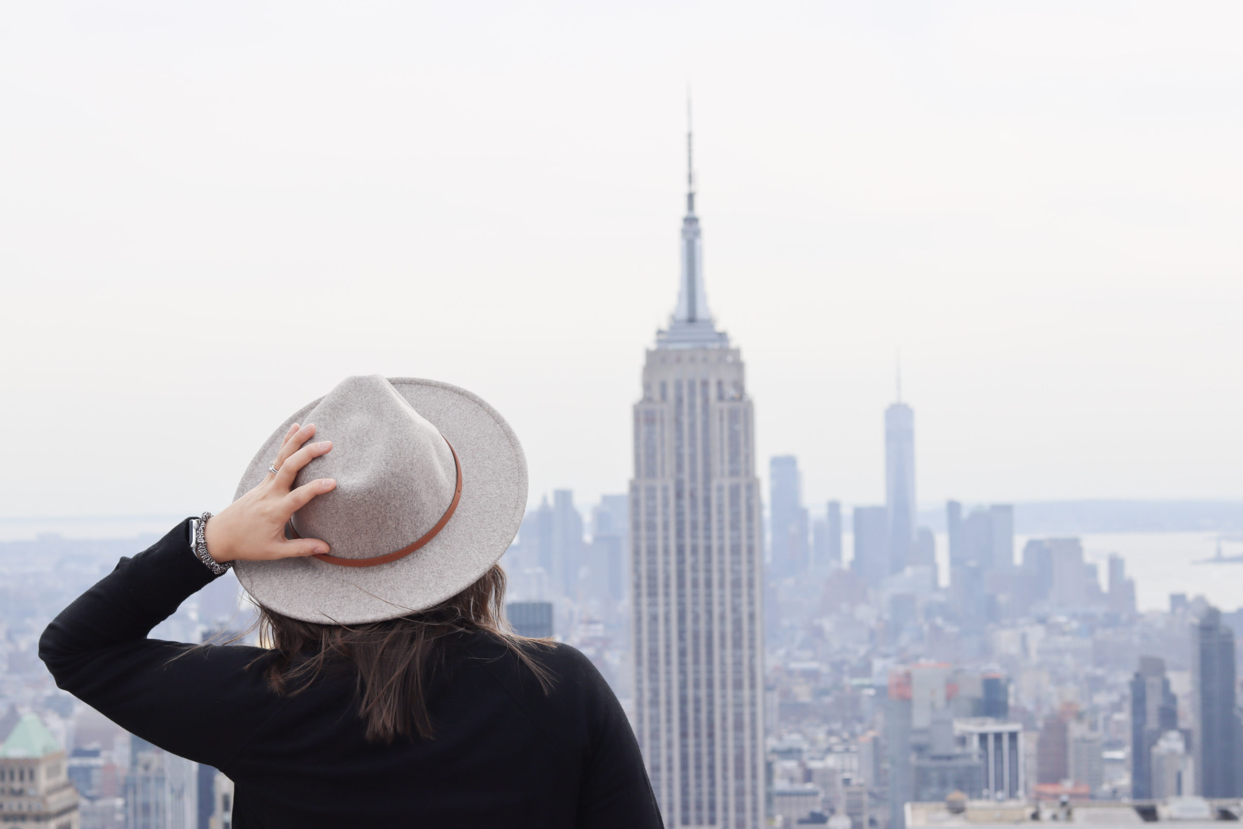 Woman looking at the Empire State building from Top of the Rock, one of the Instagram spots in NYC