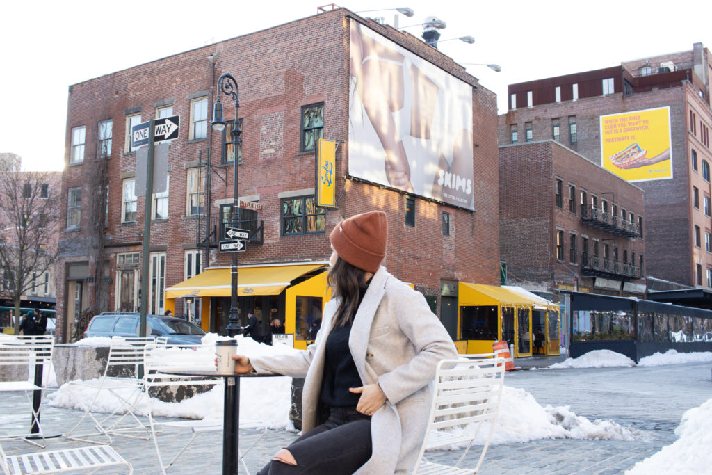 Woman sitting in Gansevoort Plaza for an instagram photo