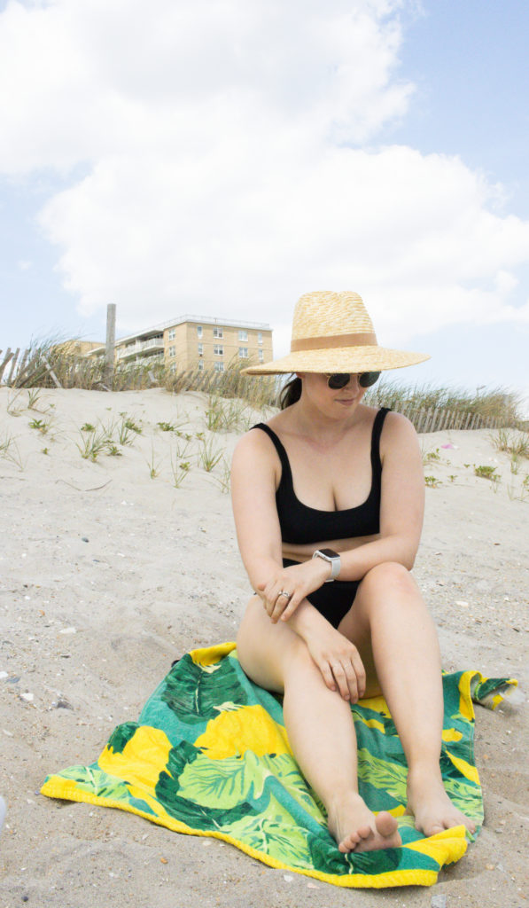 Woman sitting on Rockaway beach in the summer