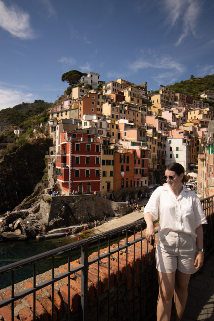 Women standing with one of the Cinque Terre towns in the background.