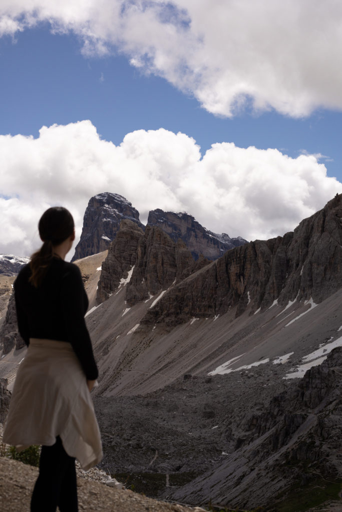A women looking out at a mountain range when hiking in the Dolomites
