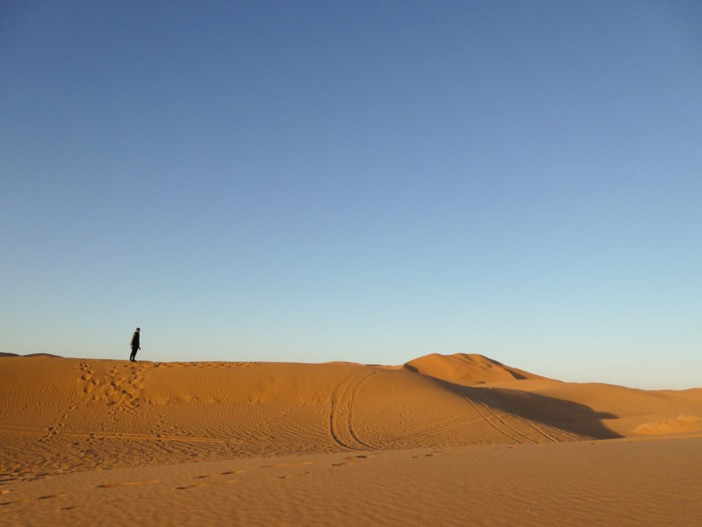 Man standing on a dune in the Sahara Desert, Morocco