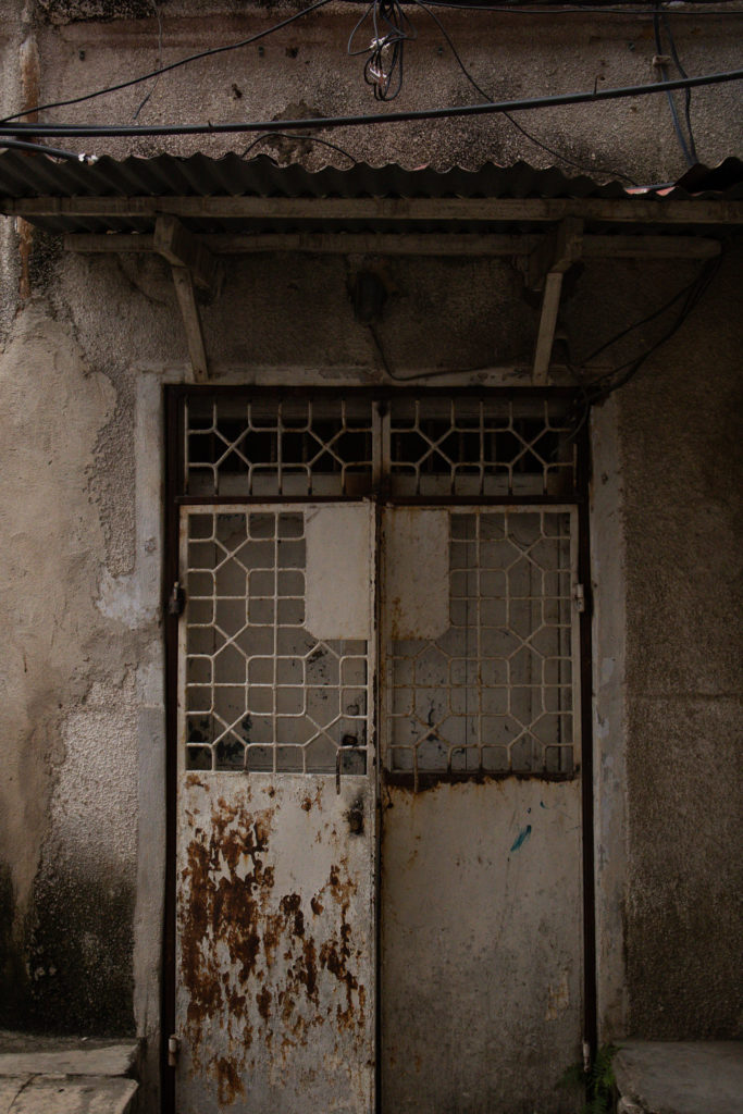 A metal door against a white building in Stone Town Zanzibar